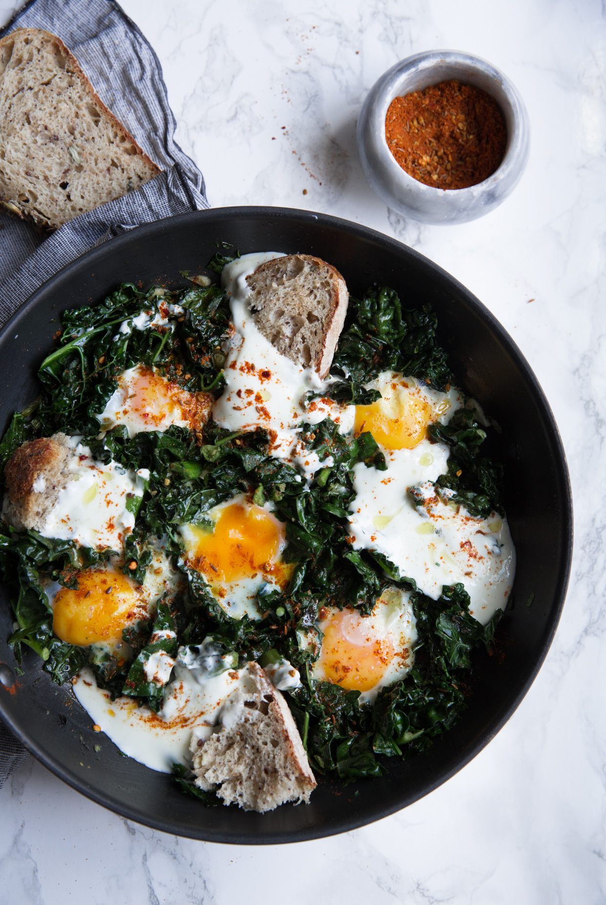 Green baked eggs with spicy yogurt